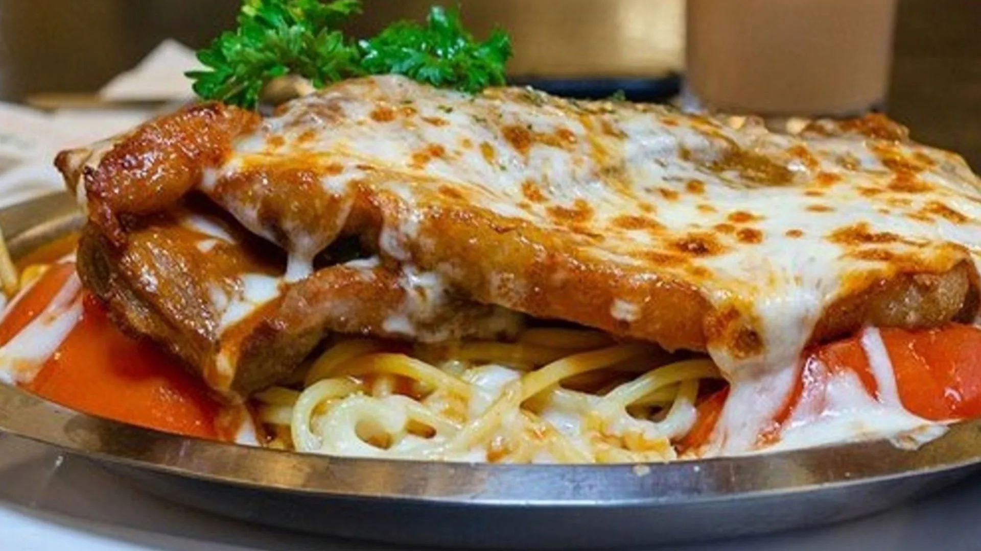 House special baked pork chop over pasta with tomato sauce and melted cheese at Smile House Cafe, a Hong Kong Style Fast Food Restaurant in San Francisco