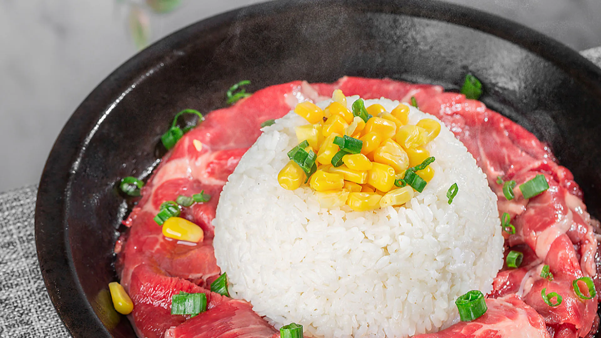 Teppanyaki raw sliced beef platter served with steamed rice and corn kernels at Smile House Cafe, a Hong Kong Style Fast Food Restaurant in San Francisco
